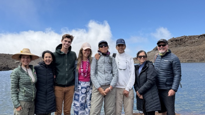 A group of people with a lake behind them