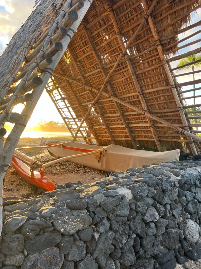 A canoe resting in a thatched shelter